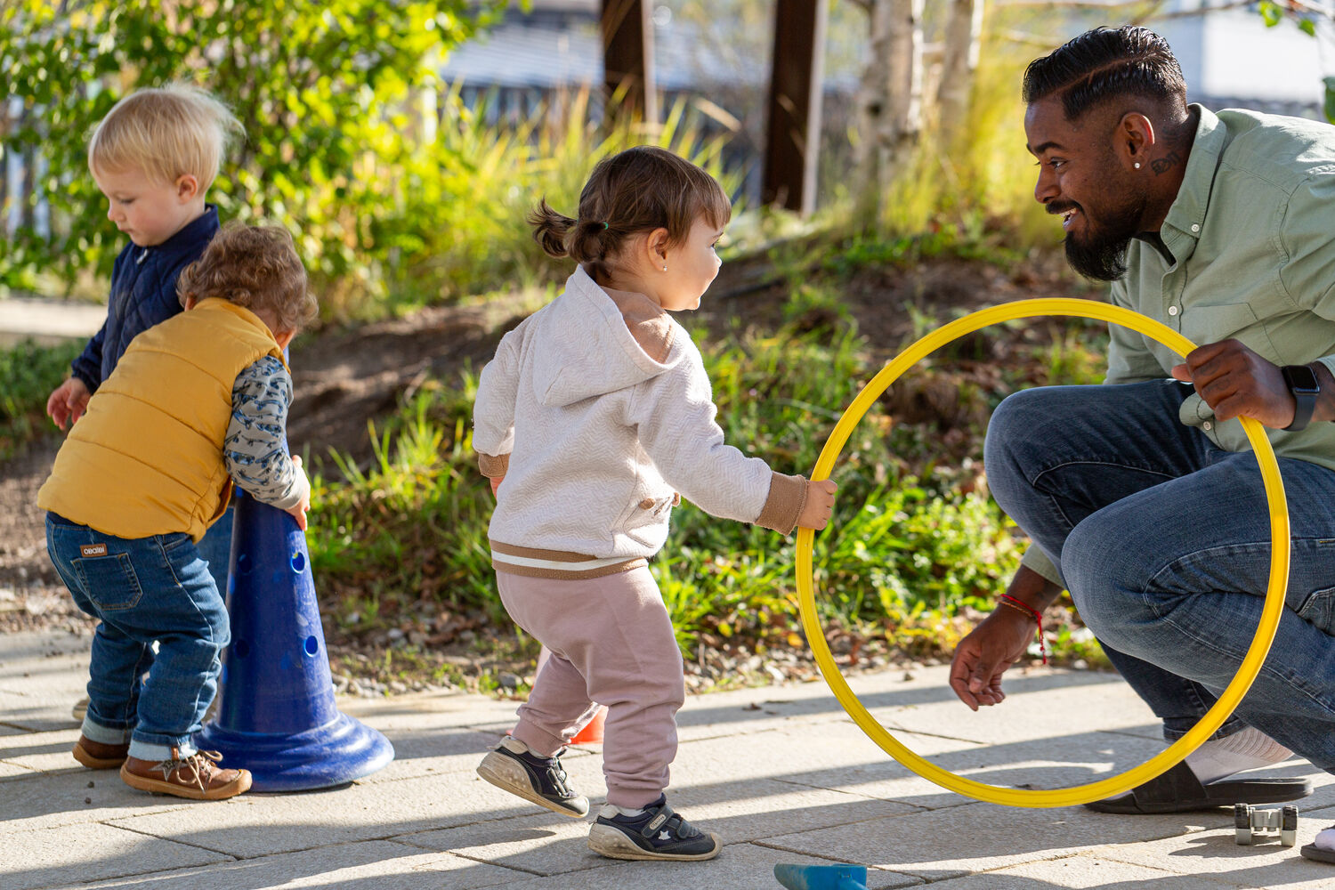 Kita kids & co City Kitaleitung spielt mit Kindern draussen