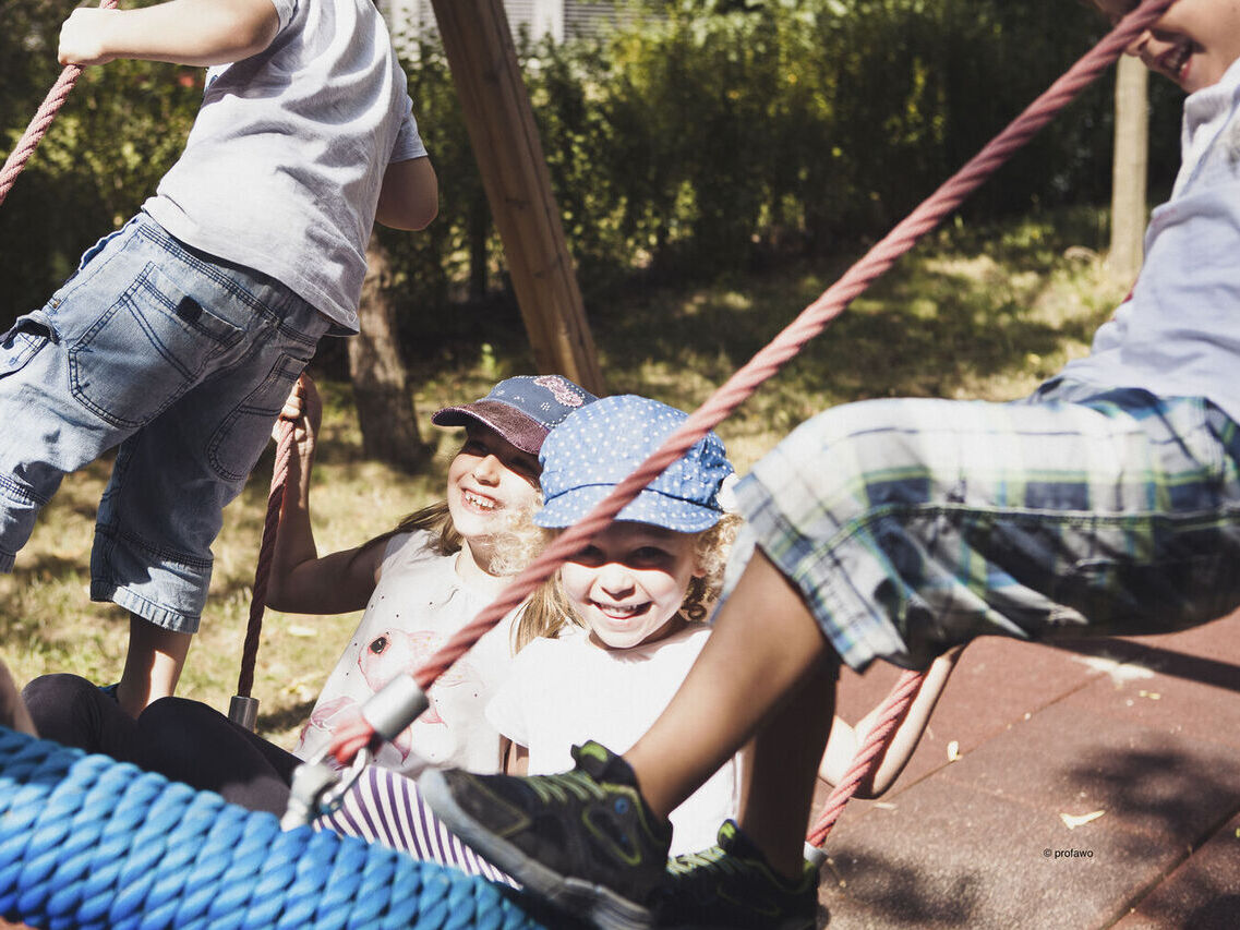 Kinder spielen während des Ferienprogramms von profawo im Garten